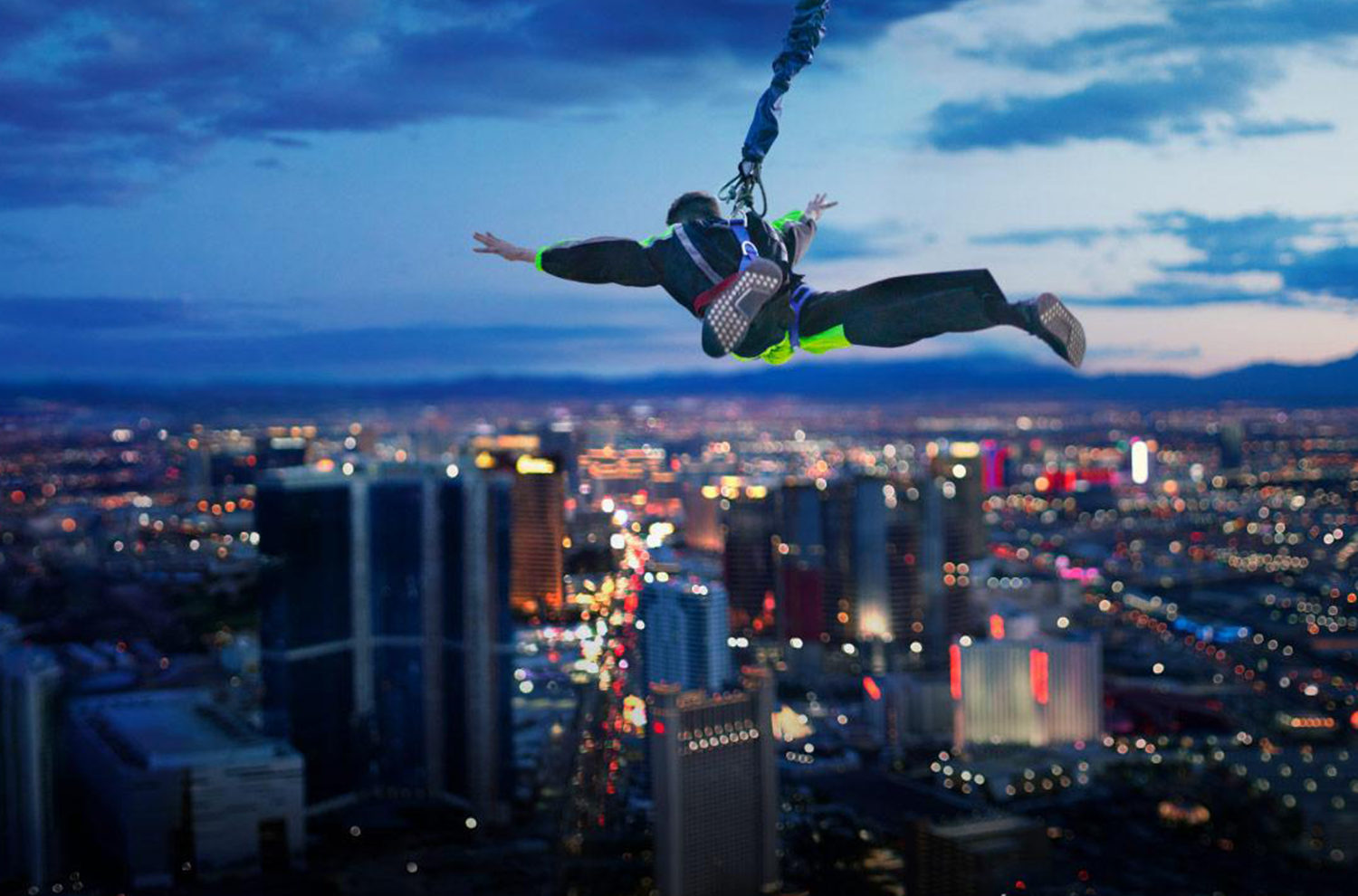 A person skydiving with a cityscape in the background